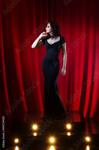 Beautiful Singing Girl on stage. Red curtain  background © Ulia Koltyrina