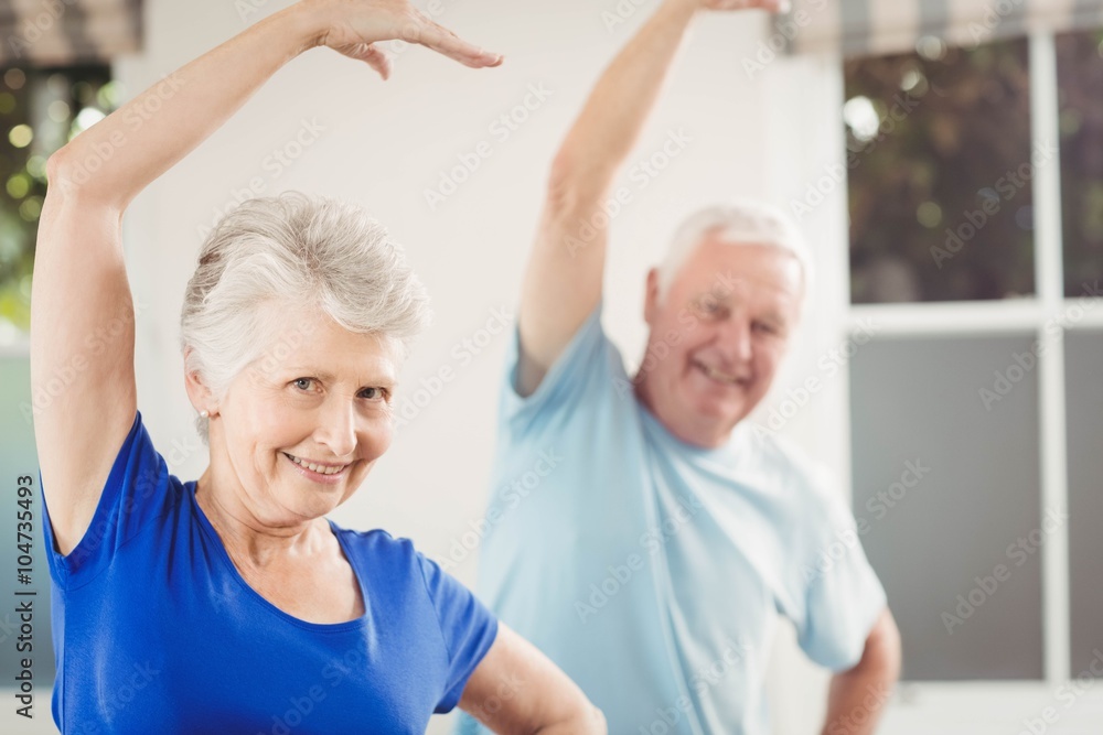 Portrait of senior couple performing stretching exercise Portrait of senior couple performing stretching exercise