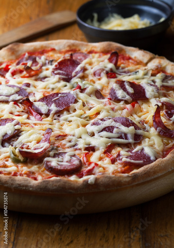 Delicious pizza with salami, tomatoes