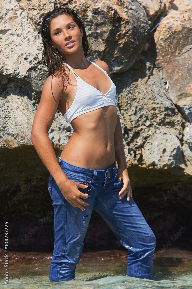 Hot spanish model wearing sexy bikini top and jeans on a sandy beach Playa  de Levante posing in the sunnny summertime day in Benidorm Spain Stock 写真 |  Adobe Stock