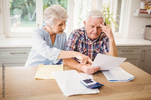 Obraz na płótnie Worried senior couple checking their bills