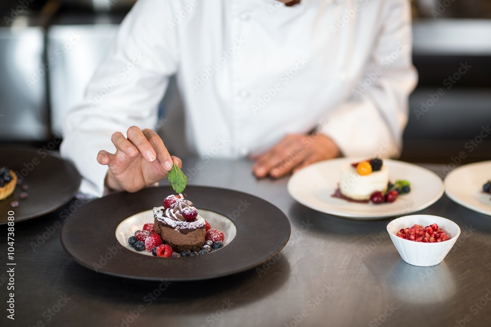 Chef putting finishing touch on dessert Chef putting finishing touch on dessert