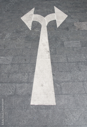 White arrow on asphalt surface.