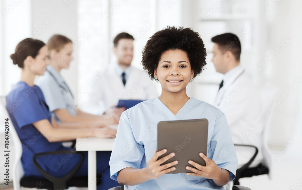 happy doctor with tablet pc over team at clinic happy doctor with tablet pc over team at clinic