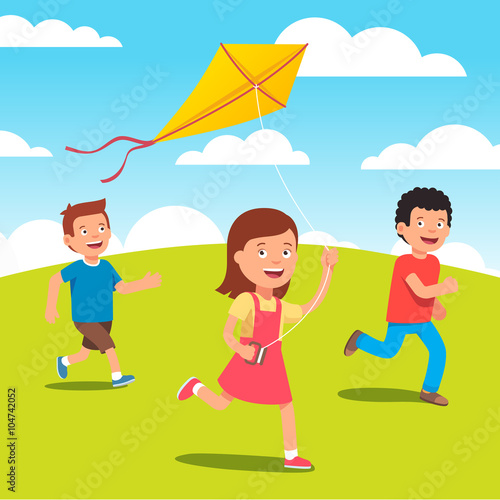 Kids playing with kite together at the meadow