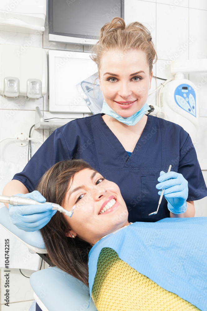 Beautiful dentist is treating teeth of the patient Beautiful dentist is treating teeth of the patient