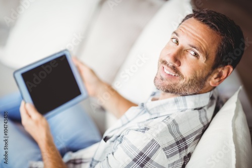 Portrait of smiling man holding digital tablet