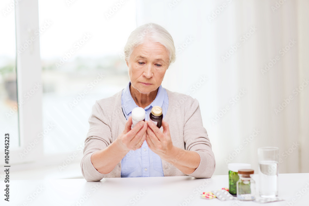 senior woman with medicine jars at home senior woman with medicine jars at home
