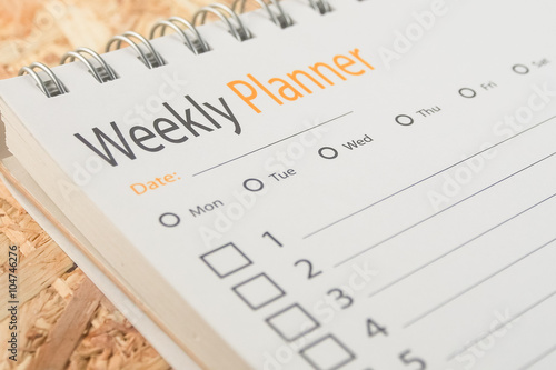 close-up word weekly planner on wooden background photo