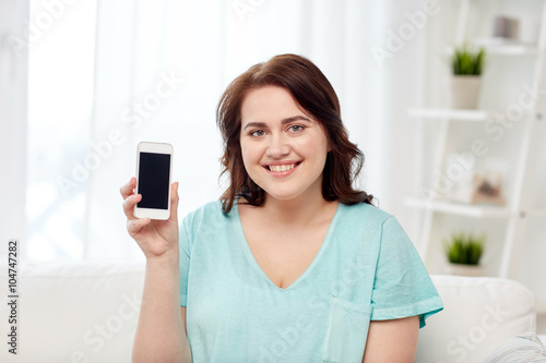 happy plus size woman with smartphone at home