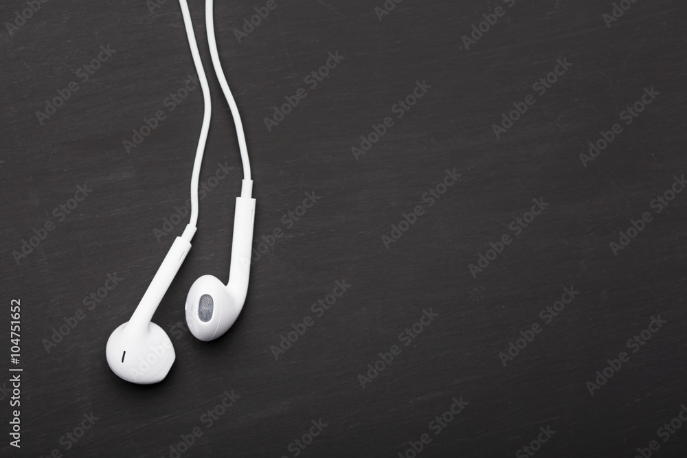 Obraz premium Białe słuchawki na czarnym tle