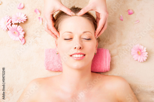 Beautiful woman enjoying facial massage at spa studio