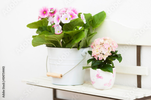 Hollyhock and hydrangea flowers on off-white shelf