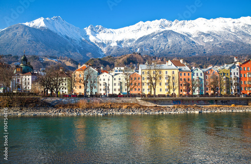  Austria, Innsbruck, the Mariahilf strasse colored houses on the Inn river with the snowy mountains in the background