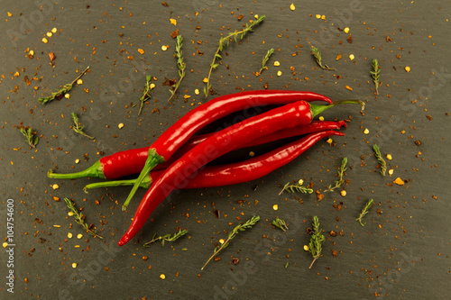 Red hot chili pepper on vintage black table. Colorful dried natural herbs and spices.