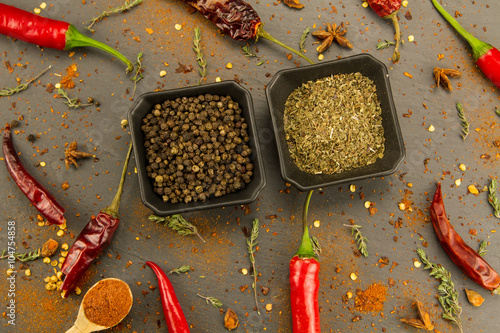 Red hot chili pepper on vintage black table. Colorful dried natural herbs and spices.
