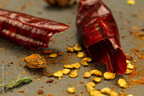 Red hot chili pepper on vintage black table. Colorful dried natural herbs and spices.