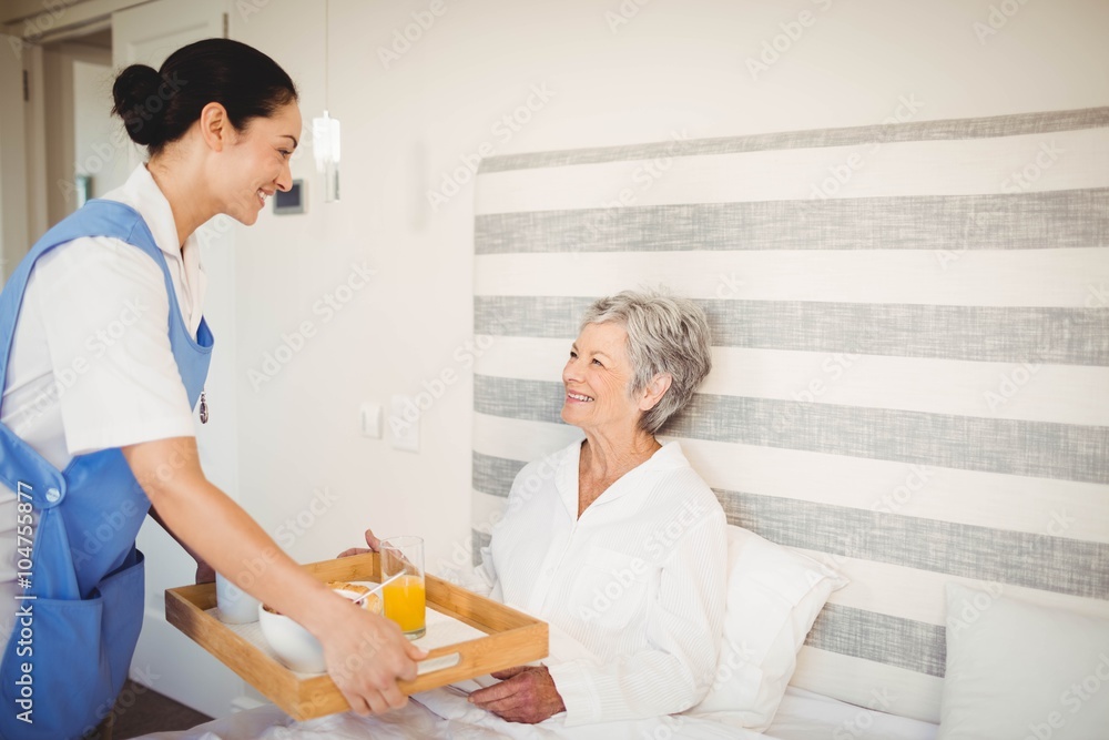 Obraz premium Nurse serving breakfast to senior woman
