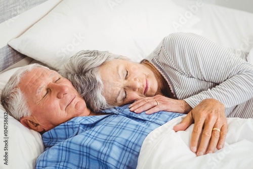 Senior couple sleeping on bed