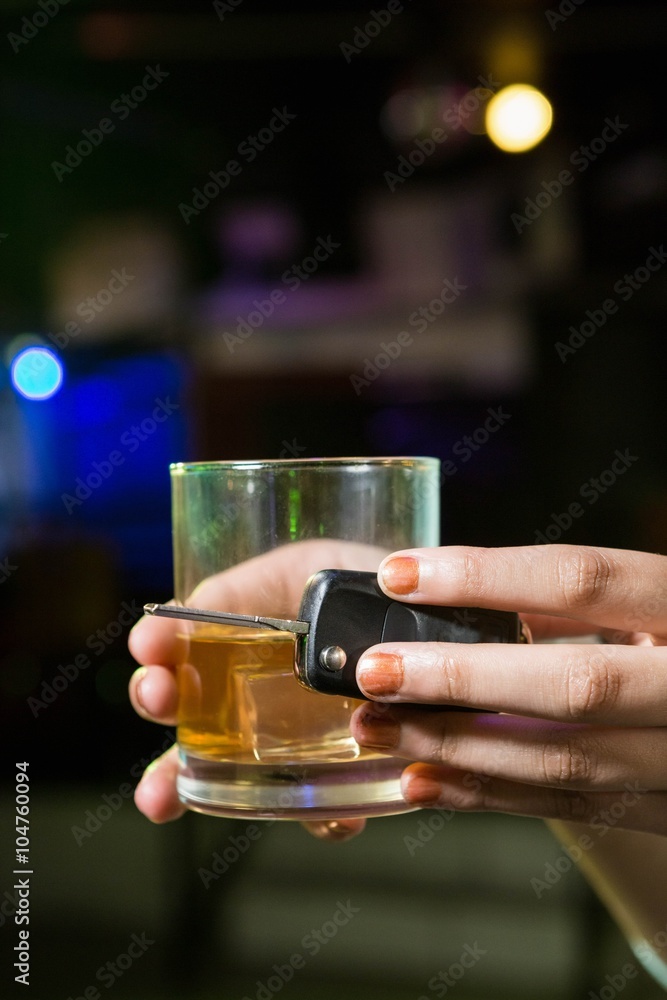 Woman holding a glass of whiskey and car keys Woman holding a glass of whiskey and car keys