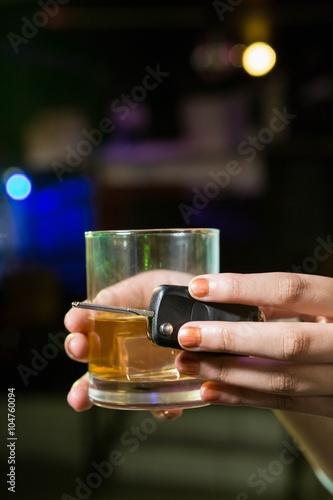 Woman holding a glass of whiskey and car keys