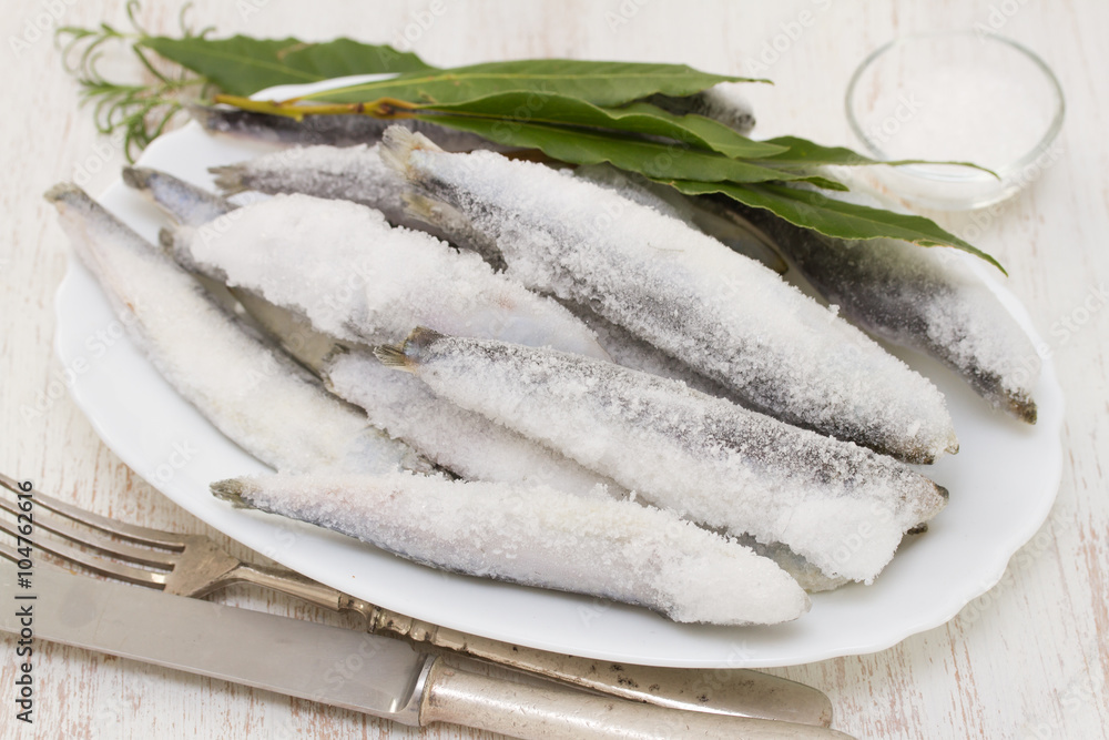 sardines in ice on white dish on white wooden background sardines in ice on white dish on white wooden background