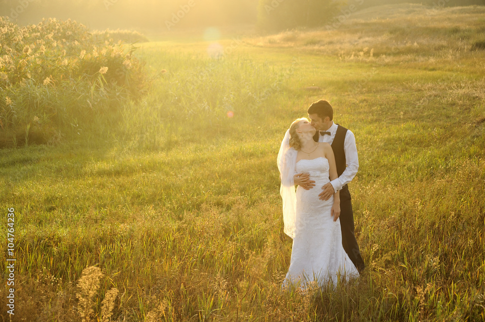 Bride and Groom Posing in the Field, filled with light