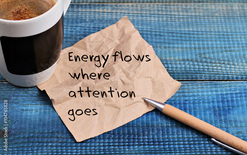 Inspiration motivation quotation Energy flows where attention goes and cup of coffee photo