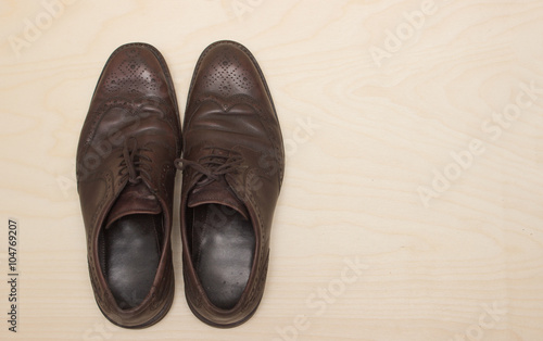 Male brown leather shoes on wooden background, flat lay