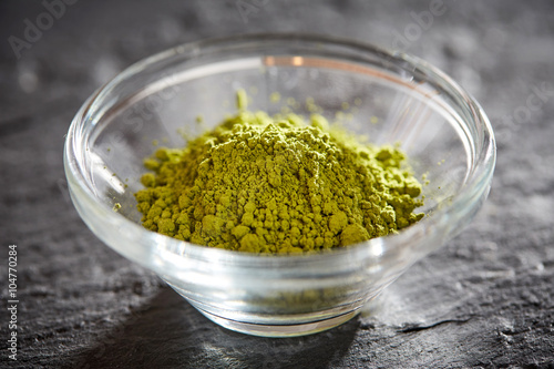 Green matcha powder in glass bowl