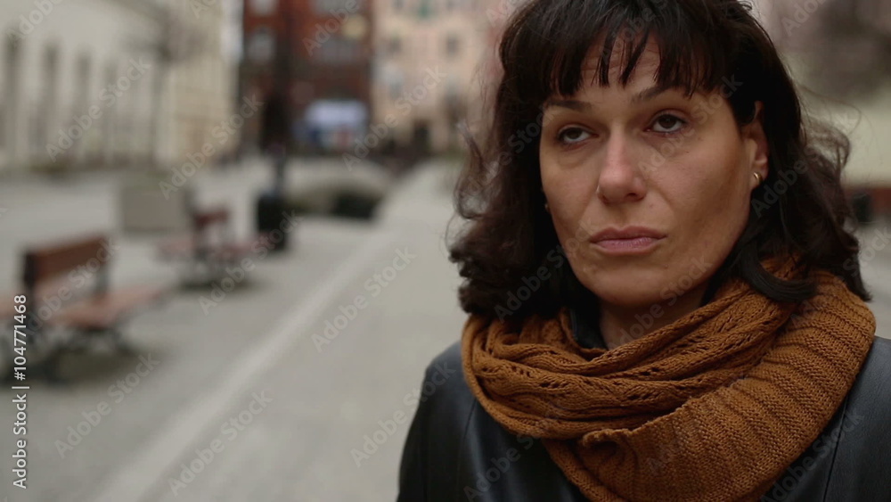 Sad and tired woman looks around in the city centre
Sad and tired woman looks around in the city centre