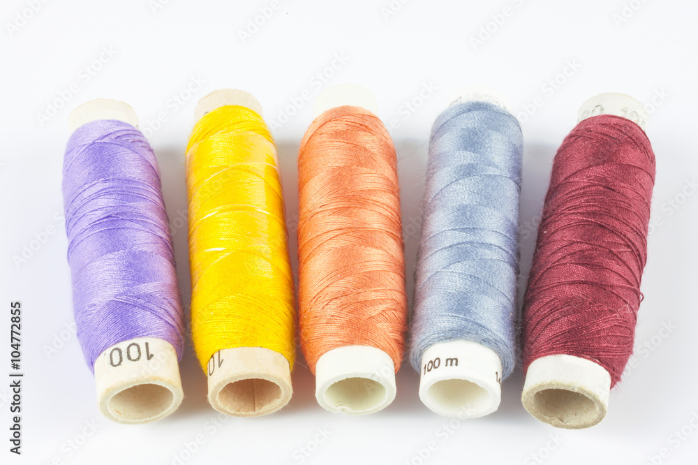 Coloured bobbins of thread on white background Coloured bobbins of thread on white background