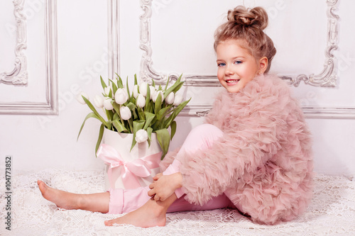 Happy girl with box with white tulips. Kids fashion
