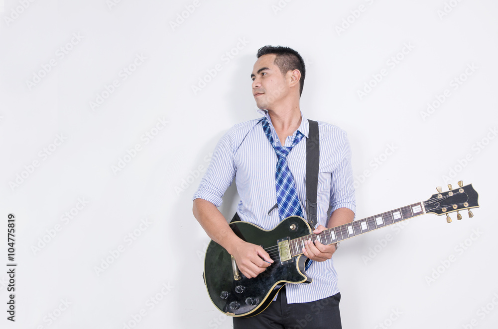 Relaxing asian business man playing electric guitar near the whi Relaxing asian business man playing electric guitar near the whi