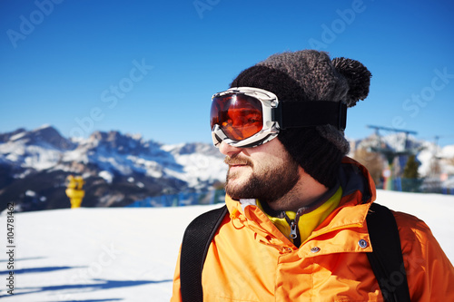 smiley skier in orange jacket and mask