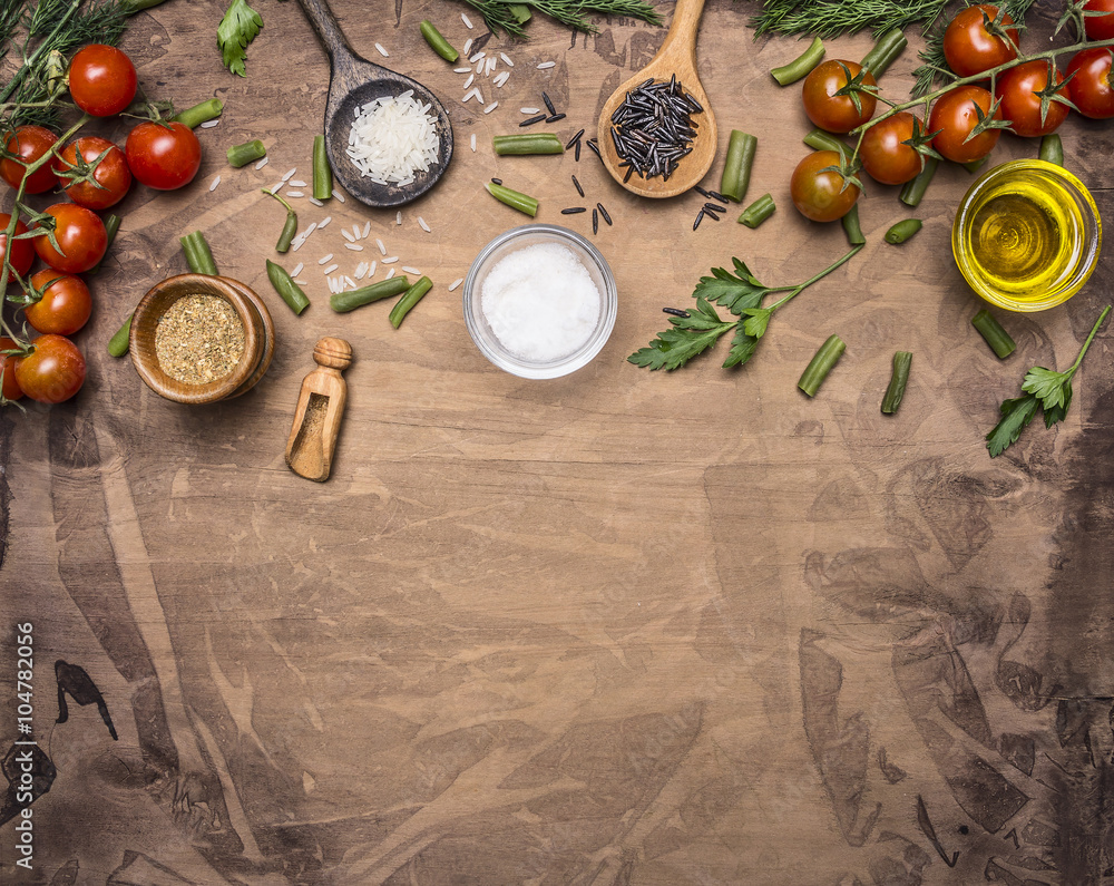 Ingredients for cooking vegetarian food  cherry tomatoes, spices, herbs, oil, colorful rice in wooden spoons border ,place for text  on wooden rustic background top view close up