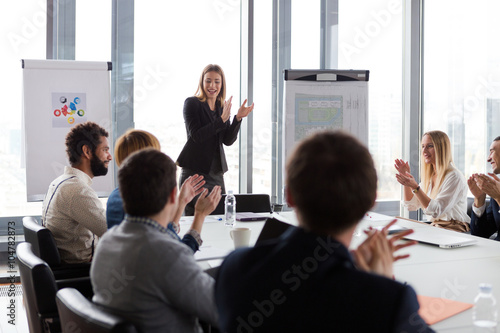Business people clapping hands during the meeting in modern office.
