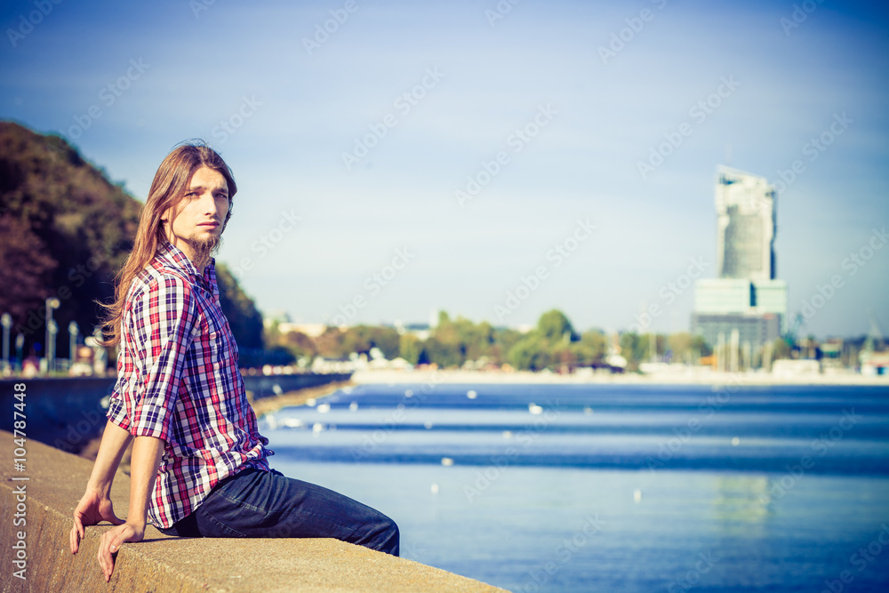 Man long hair relaxing by seaside Man long hair relaxing by seaside