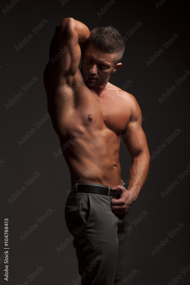 shirtless muscular man in pants posing in studio shirtless muscular man in pants posing in studio