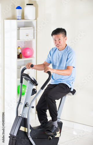 matured asian male on exercise bike