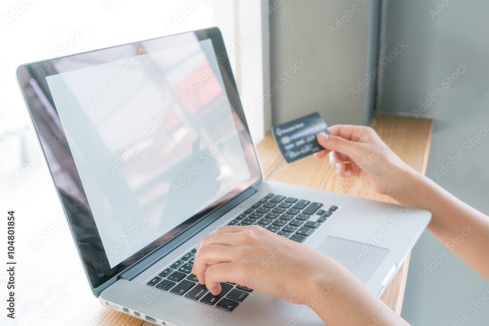Hands holding a credit card and using laptop computer for online Hands holding a credit card and using laptop computer for online