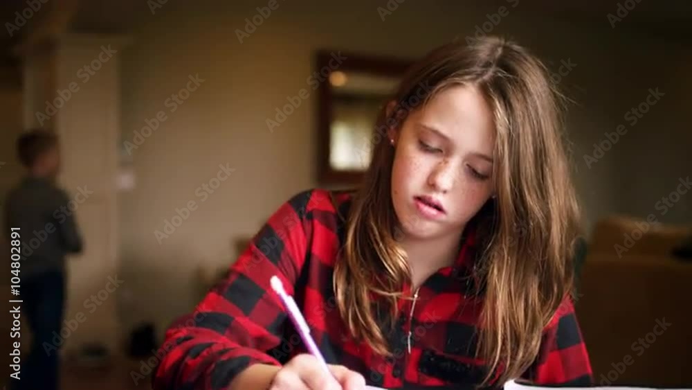 Young teen doing homework at the kitchen table