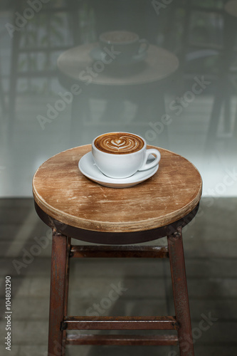 The cup of coffee costing on a wooden little table, a cappuccino, coffee with milk, fragrant a cappuccino