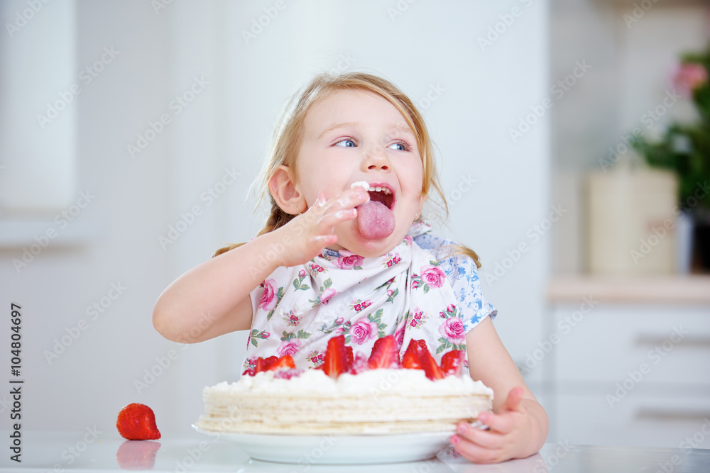 Kind leckt Sahne vom Finger beim Kuchen essen Kind leckt Sahne vom Finger beim Kuchen essen