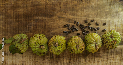 Ripe Sugar-apple Seeds by Unbroken Fruits on Wooden Table photo