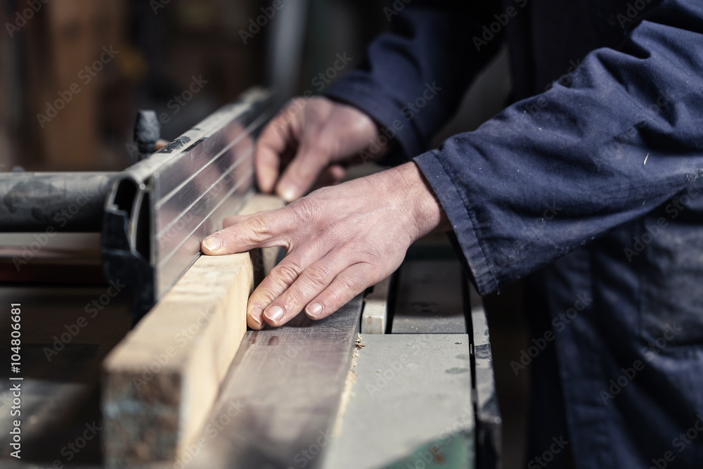 Carpenter's hands cutting wood with tablesaw Carpenter's hands cutting wood with tablesaw