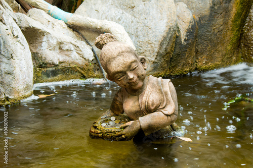 Stone statue woman swim in the pool.