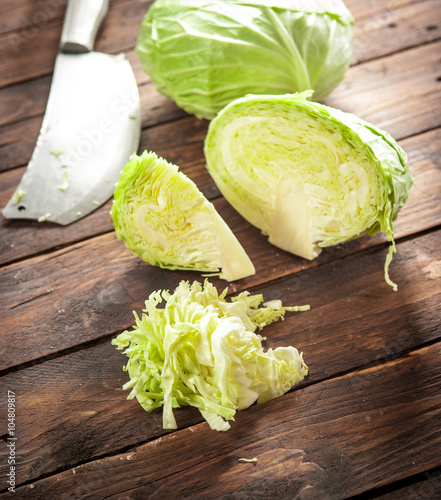 Cabbage with knife on old wooden desk