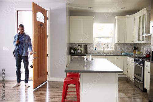 Man Coming Home From Work And Opening Door Of Apartment