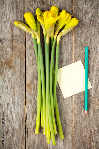 Daffodil flowers and empty sticky note